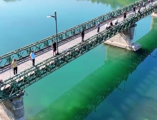 The metal Old Bridge of Buna crossing the clear green river near Shkodra