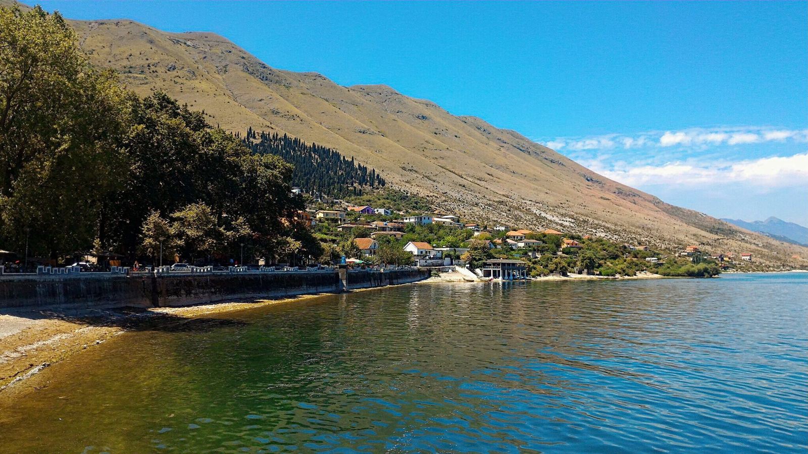 The lakeside village of Shiroka on the shore of Lake Shkodra with mountains behind