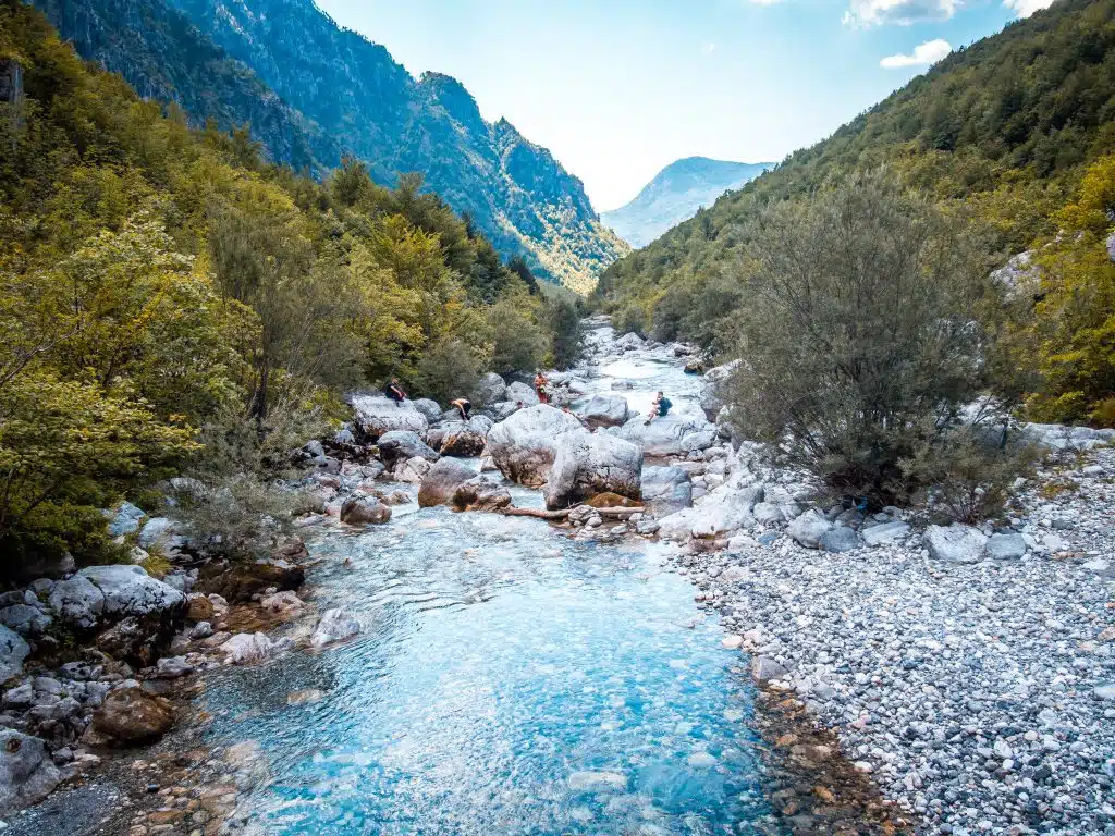 Clear mountain water between white stones in the Valbona valley below the pass